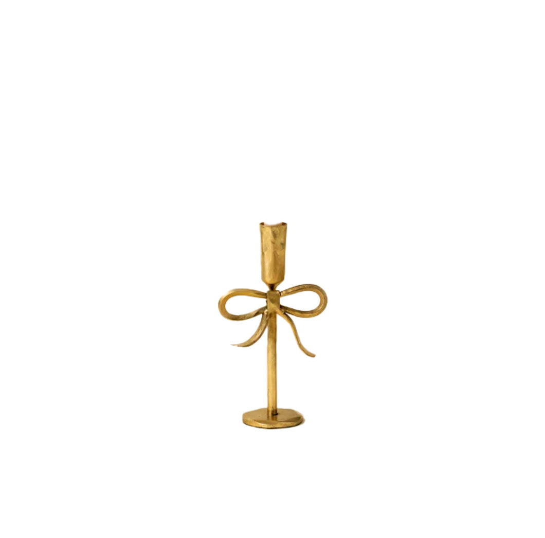 Short gold candle holder with bow design on a white background
