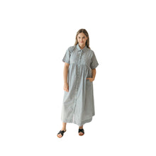 Woman wearing a charcoal and white striped dress on a white background