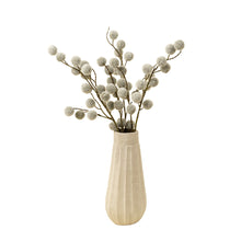 artificial spray branches with fuzzy pom poms in a vase on a white background