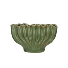 Green ceramic vase with ribbed texture and divided sections on a white background