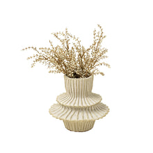 Artificial heather spray branches in a vase on a white background