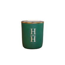 Halliday House signature winter candle in a green vessel with a gold lid and H/H on the front in gold 
