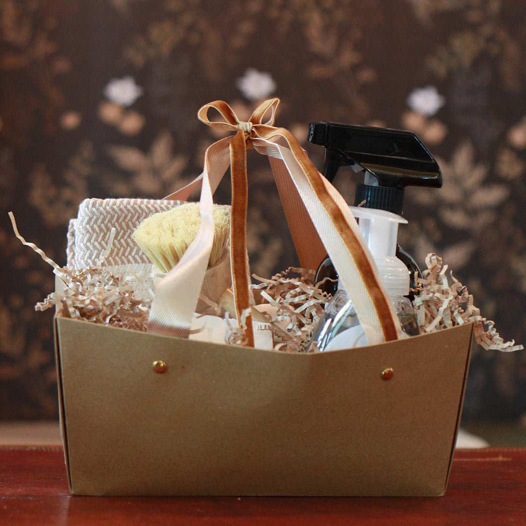 Gift basket with Kitchen supplies and a bow on a wooden surface