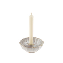 ceramic bowl shaped lotus candleholder with a white candle on a white background
