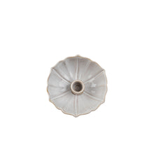 Ceramic lotus shaped candle holder on a white background from birds eye view
