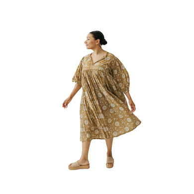 Woman wearing a yellow patterned dress on a white background