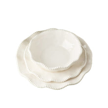 cream melamine dinner plate, salad plate, and bowl stacked with wavy dotted edges