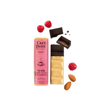 Café-Tasse noir praline amande & framboise chocolate bar surrounded by almonds and raspberries on a white background 
